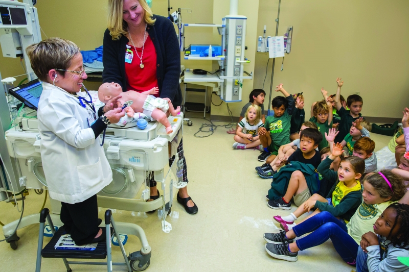 Arnold tells a group of school children including her son, Will (front row, black shirt), about training parents and doctors to help newborns at the simulation center at Johns Hopkins in St. Petersburg, Fla.