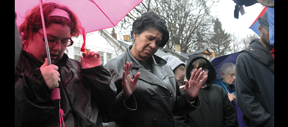 Mourners gather at a vigil on Franklin Ave. in Wilkinsburg, Pa., for mass shooting victims who were ambushed at a party in 2016. The death toll  included five adults and an 8-month-old fetus. Richard Garland, of the Graduate School of Public Health, acts as a mediator to try to prevent conflicts from turning deadly. (Photo: John Heller, © Pittsburgh Post-Gazette, 2019, all rights reserved. Reprinted with permission)