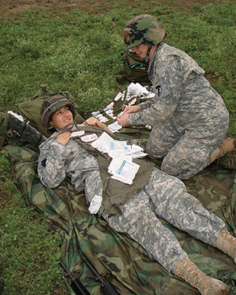 Kimberly Bell and a fellow Army National Guard recruit in a medic exercise during active duty training.