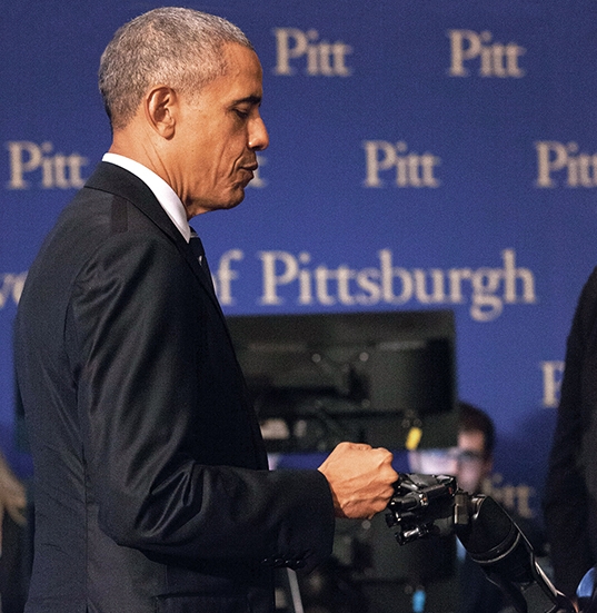President Obama fist-bumps Nathan Copeland's robotic hand.